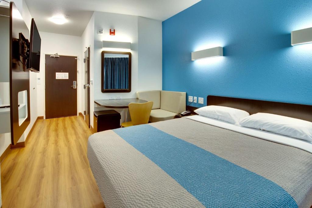 une chambre d'hôtel avec un lit et un mur bleu dans l'établissement Motel 6-Poplar Bluff, MO, à Poplar Bluff