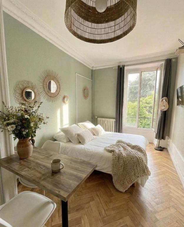 een slaapkamer met een bed en een houten tafel bij Bois Émeraude in Aix-les-Bains