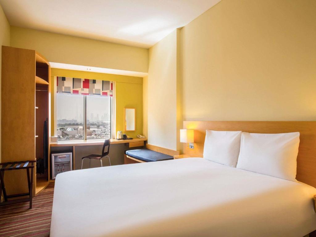 a hotel room with a large bed and a desk at ibis Deira Creekside Dubai in Dubai