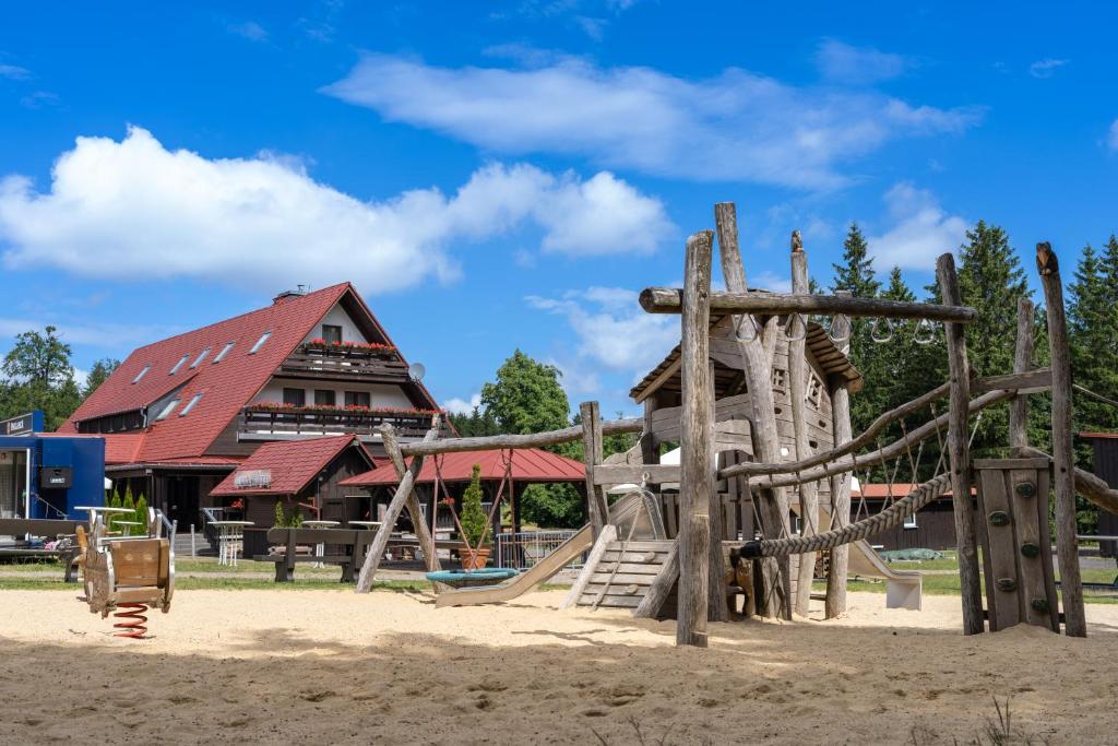 a playground in front of a building with a slide at Berggasthof Heuberghaus, direkt am Rennsteig in Friedrichroda
