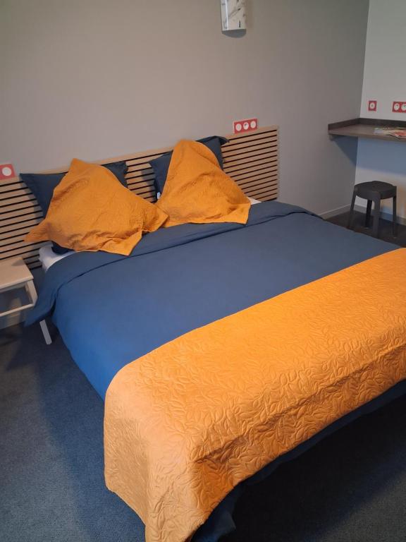 En eller flere senge i et værelse på Hôtel le beau séjour