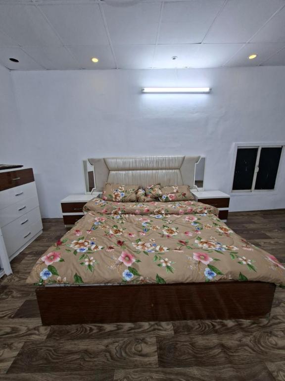 a bedroom with a large bed with flowers on it at غرفه مفروشه in Mogayra