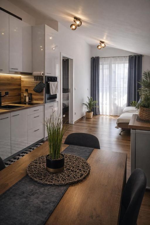 a kitchen and living room with a wooden table with a dining room at Charming City Apartment SIYANA - Self Check-in in Panagyurishte