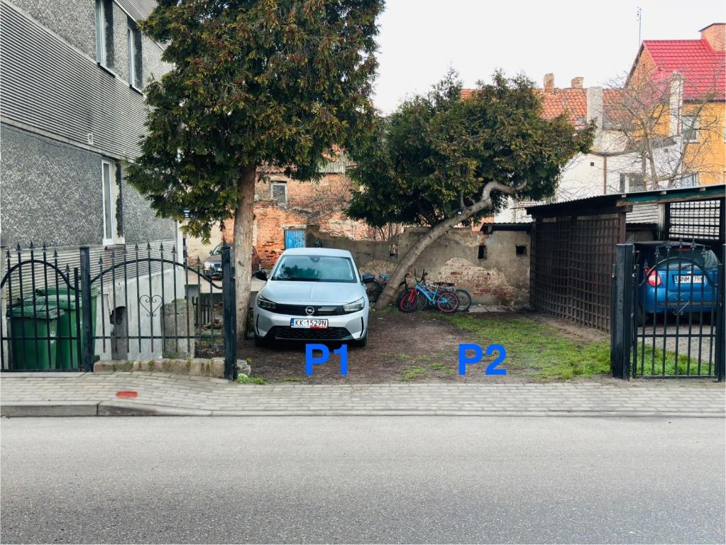 een auto geparkeerd op een parkeerplaats naast een hek bij CitiMarina56 in Brodnica