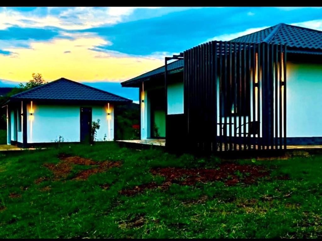 ein Haus mit Zaun auf einem grünen Feld in der Unterkunft Mountain House Transalpina in Novaci-Străini