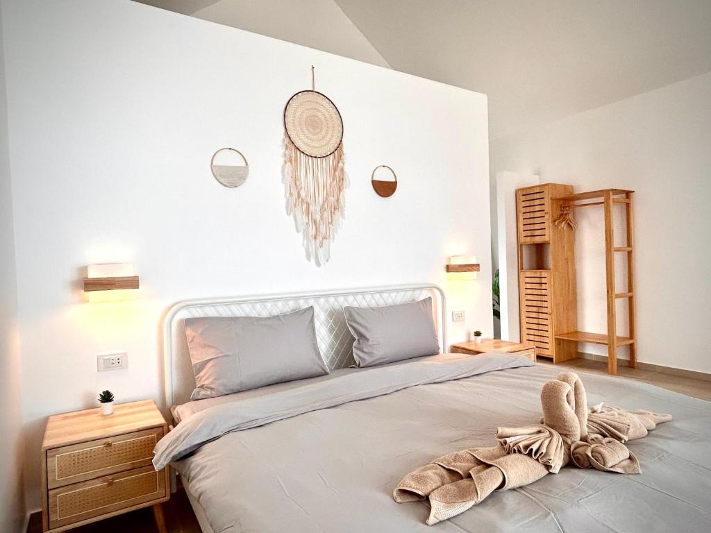 een slaapkamer met een groot bed met een handdoek erop bij The Cosy Sunset Beach Resort in Thongsala