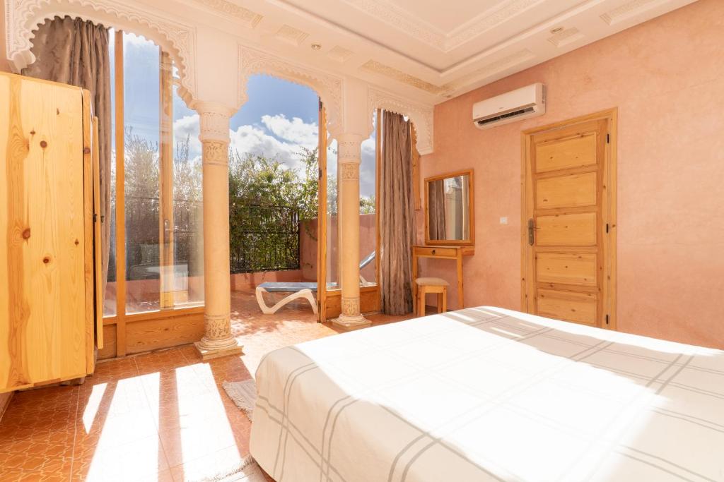 a bedroom with a bed and a large window at Villa Korima in Marrakesh