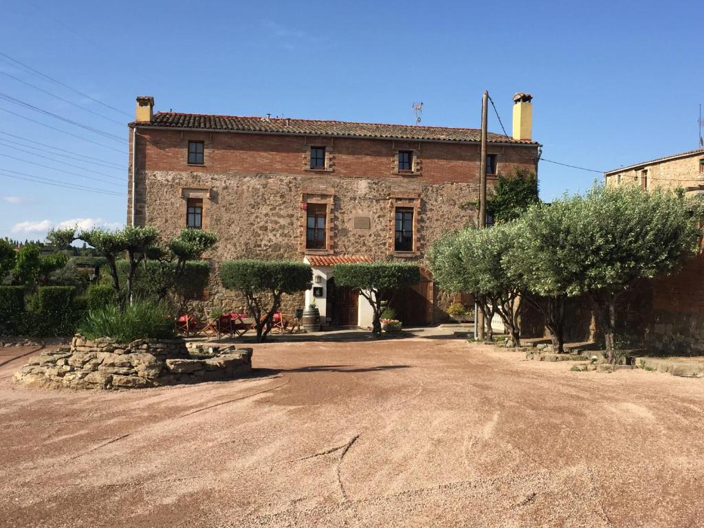 ein altes Backsteingebäude mit Bäumen davor in der Unterkunft HOTEL RESTAURANT TURÓ de la TORRE in Manresa