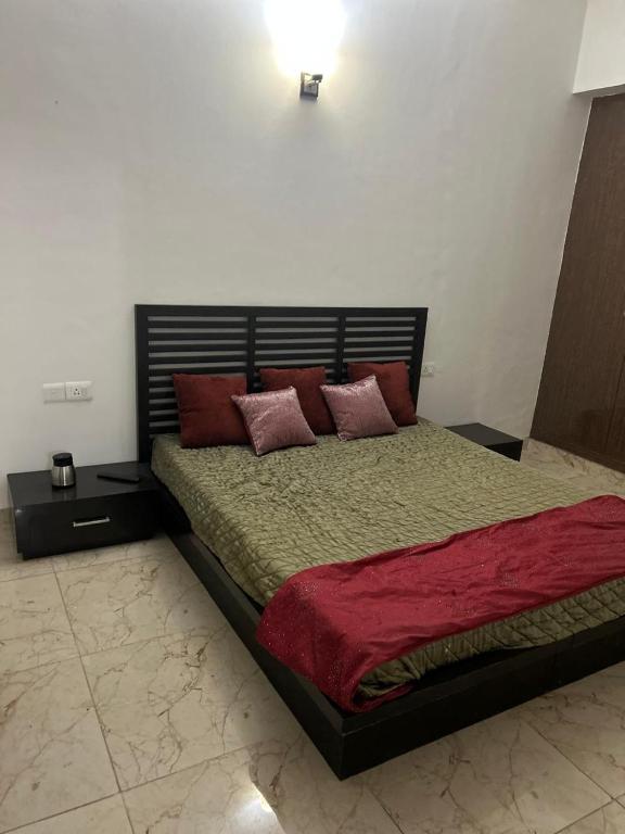a bedroom with a large bed with red pillows at north eye in Noida