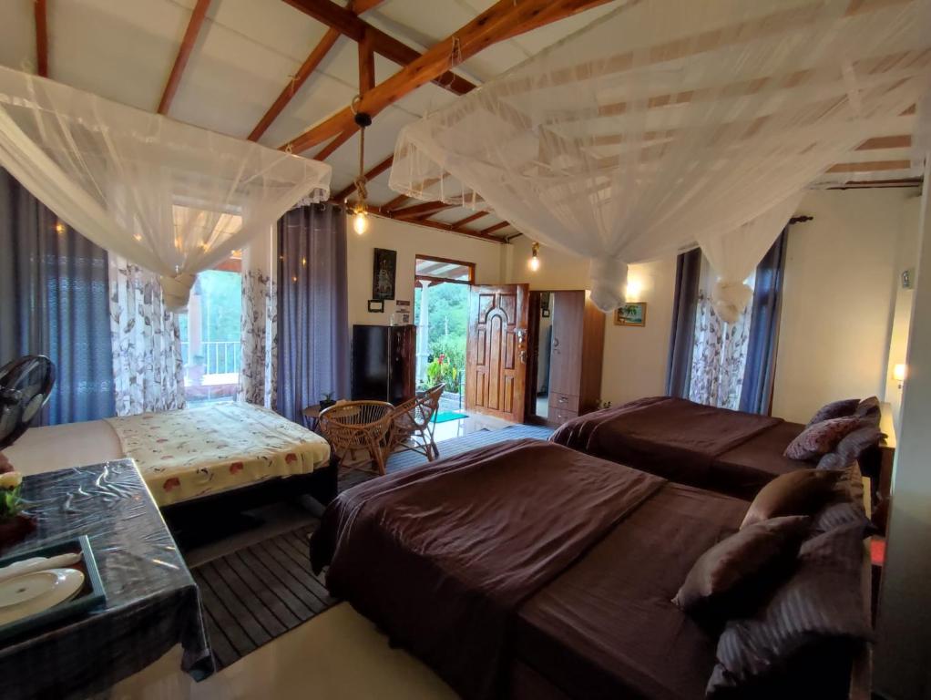 een slaapkamer met 2 bedden en een bank bij Ella Black Bridge View Cottage Sri Lanka in Ella