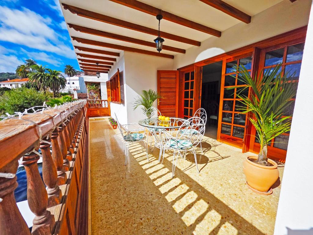 eine Terrasse mit Tisch und Stühlen auf einem Balkon in der Unterkunft Pension Casa Esperanza in Teror