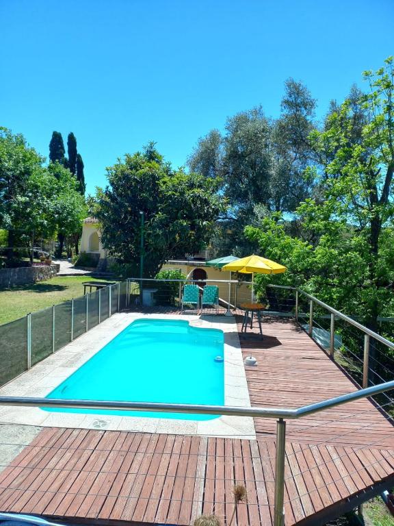 einen Pool auf einer Holzterrasse mit einem Sonnenschirm in der Unterkunft Tere & Tino Cabañas in Río Ceballos