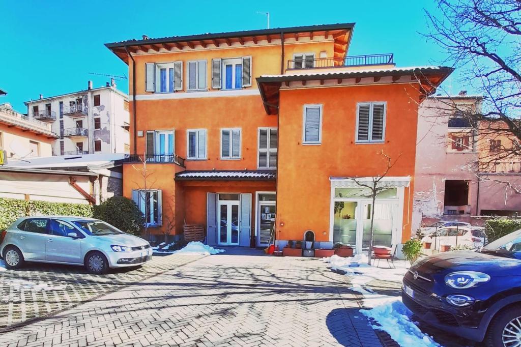 a large orange building with cars parked in front of it at Albergo Covili in Pavullo nel Frignano