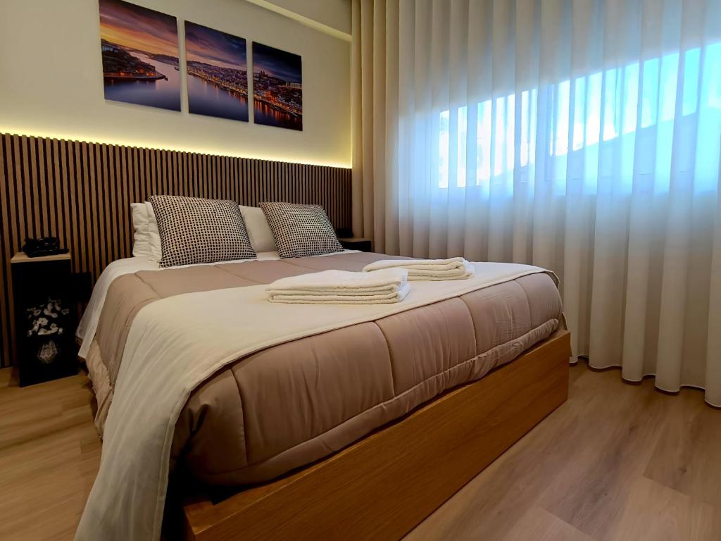 a bedroom with a large bed with towels on it at Feel Porto in Bolhão "Metro at your doorstep" in Porto