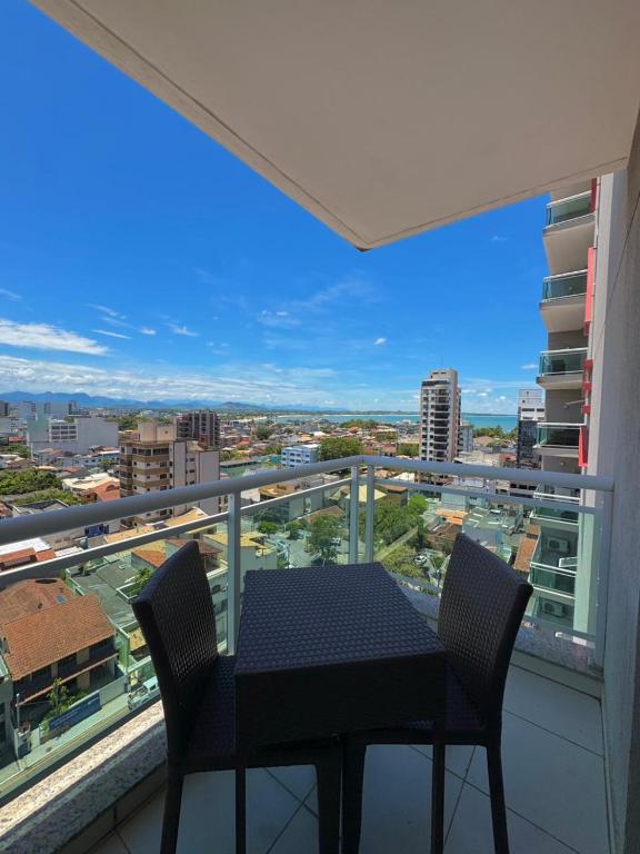 een tafel en stoelen op een balkon met uitzicht bij Studio vista panorâmica completo in Macaé