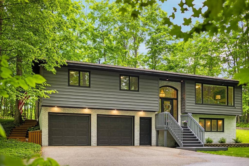 une maison grise avec un garage dans l'établissement Private & Convenient-Hot tub-Fire Pit-Game room!, à Petoskey