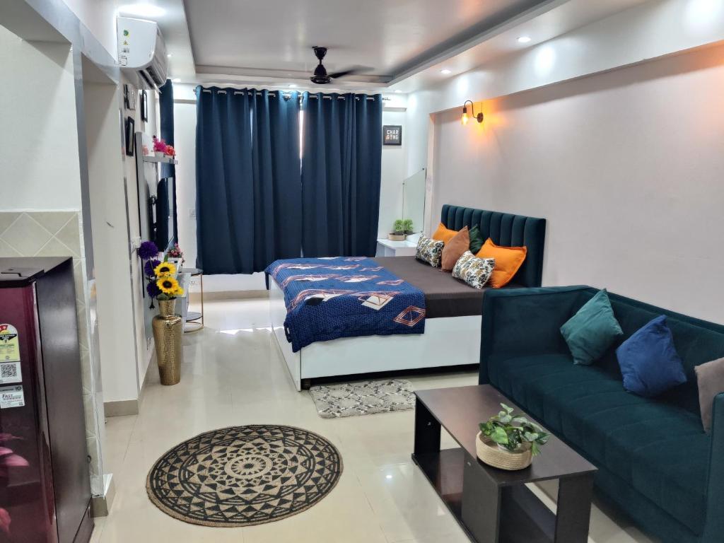 een woonkamer met een bank en een blauw gordijn bij Dristy homez in Noida