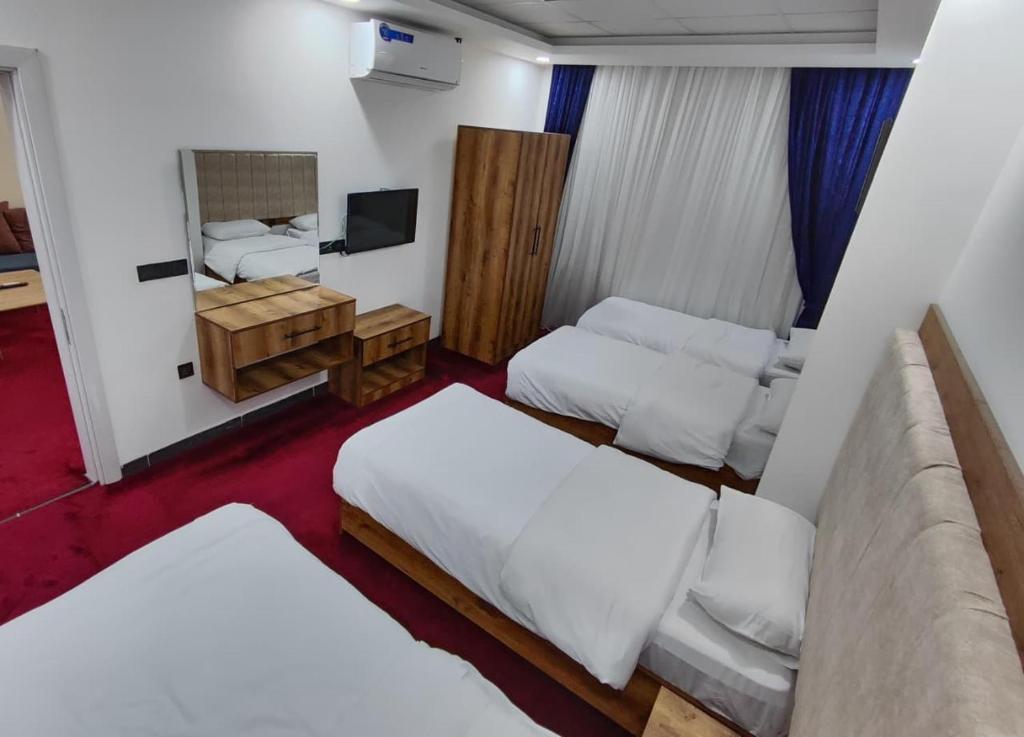 ein kleines Zimmer mit zwei Betten und einem Fernseher in der Unterkunft Danzha Hotel 1 in Erbil