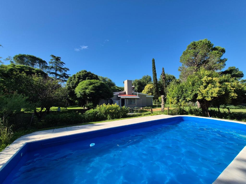 een zwembad voor een huis met bomen bij Oasis in Villa Anizacate
