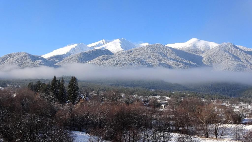 een bergketen met sneeuw bedekte bergen in de verte bij Mountainview Apartment Ski, Spa & Thermal in Bansko