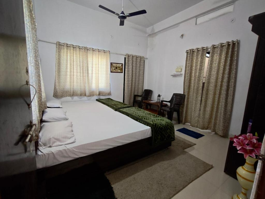 a bedroom with a bed and a table and chairs at NANDI Home's ujjain in Ujjain