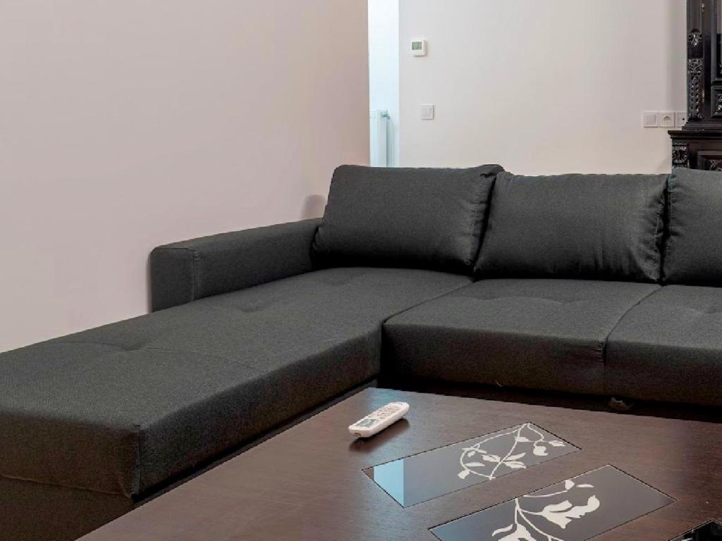 a black couch with a remote control on a table at VASKO Luxury Suites 4 in Siátista