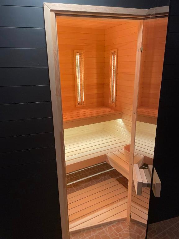 a wooden sauna with two windows in a room at Natali Apartmanház in Eger