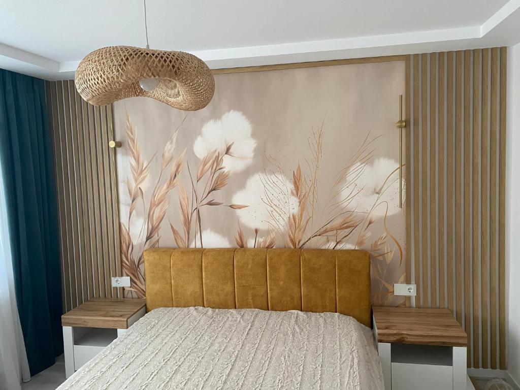 a bedroom with a bed and a wall with flowers at Central Nest in Tecuci
