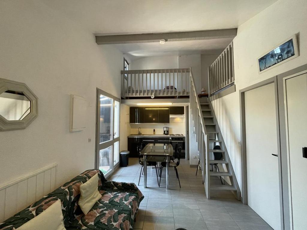 ein Wohnzimmer mit einer Treppe, die zu einer Küche führt in der Unterkunft Appartement T2 Mezzanine avec Terrasse Proche Lac - Animaux Acceptés ! - FR-1-379-27 in Vieux-Boucau-les-Bains