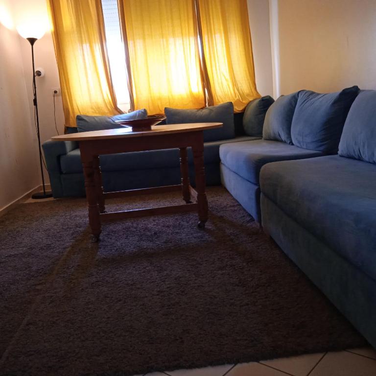 een woonkamer met een blauwe bank en een tafel bij Séjour idéal in Rabat