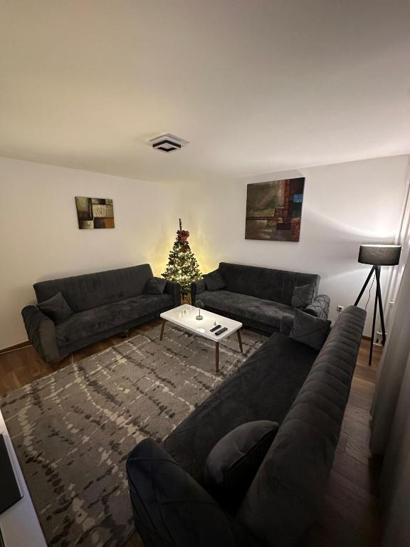 a living room with a couch and a christmas tree at Veneto Apartment in Prishtinë