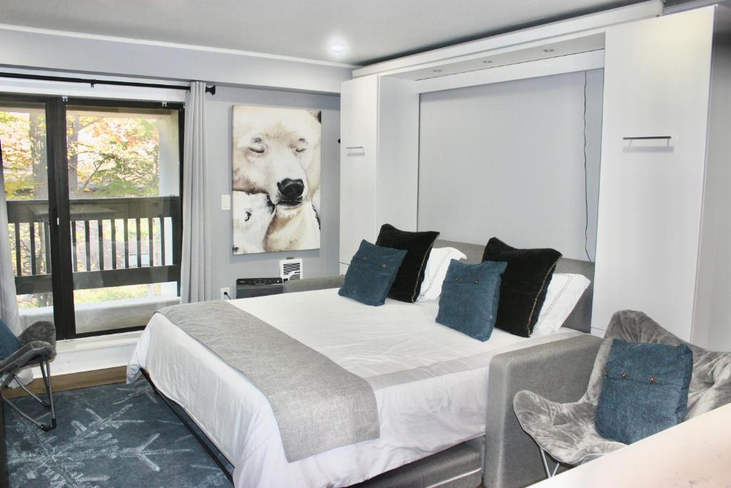 een slaapkamer met een groot bed met een foto van een hond bij Ski Condo with Garage Parking and Pool in Killington