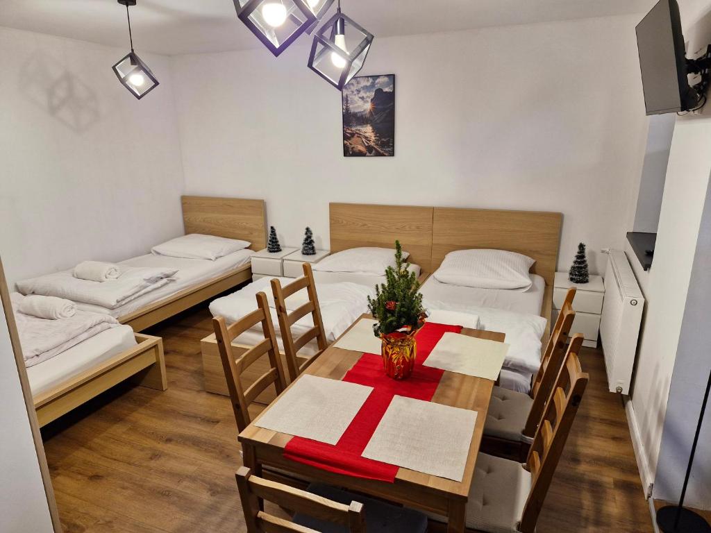 een kamer met twee bedden en een tafel en stoelen bij Apartamenty Dzika Orlica in Zieleniec