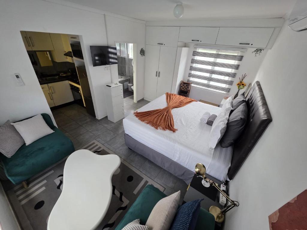 - une vue sur une chambre avec un lit et une chaise dans l'établissement Casa-Pel Guest Wing, à Palatswe