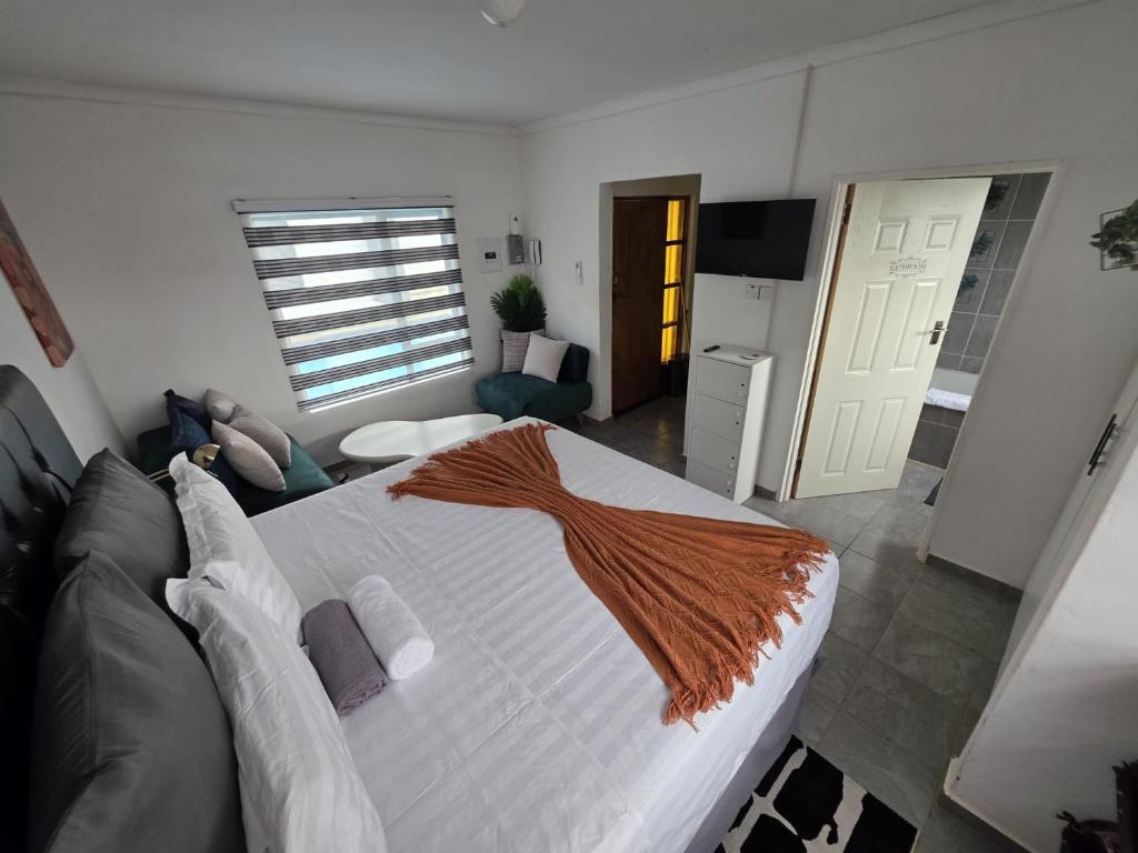 a bedroom with a large white bed and a kitchen at Casa-Pel Guest Wing in Palatswe