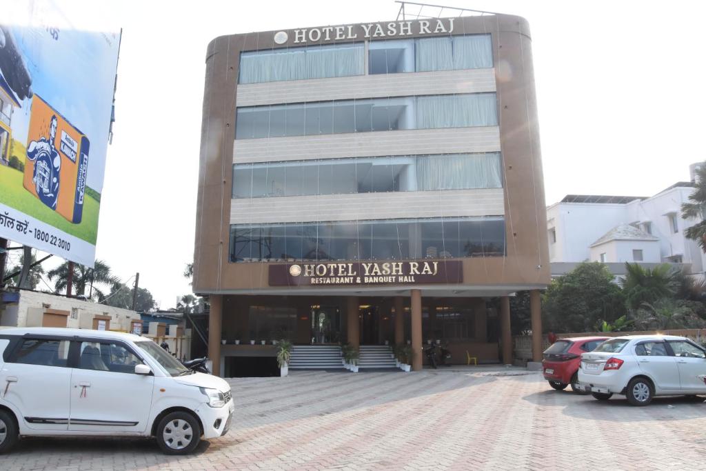 two cars parked in a parking lot in front of a building at Hotelyashraj in Pipra Dewās