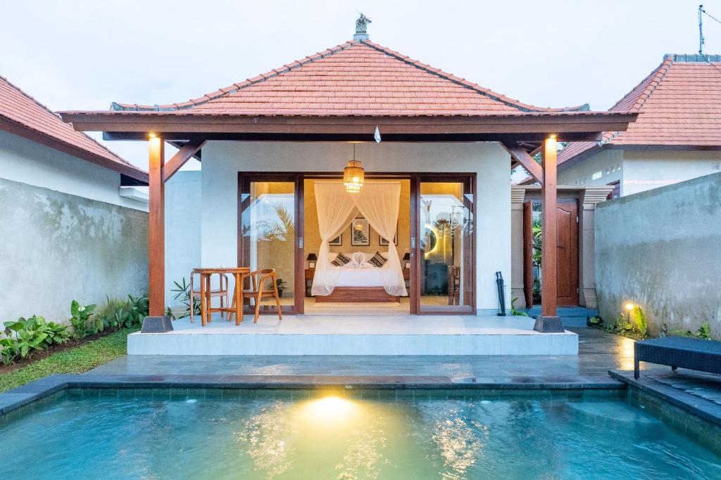 een huis met een zwembad voor een huis bij Akar Villa in Ubud
