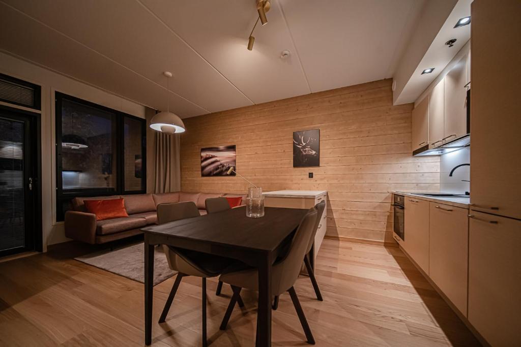 a kitchen and living room with a table and a couch at Levillas Lingonberry D26 in Levi