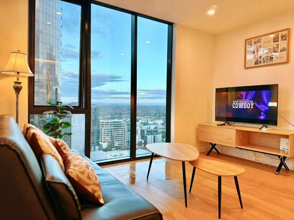 a living room with a couch and a flat screen tv at Prospect Box Hill - Magnificent View 2B1B in Box Hill