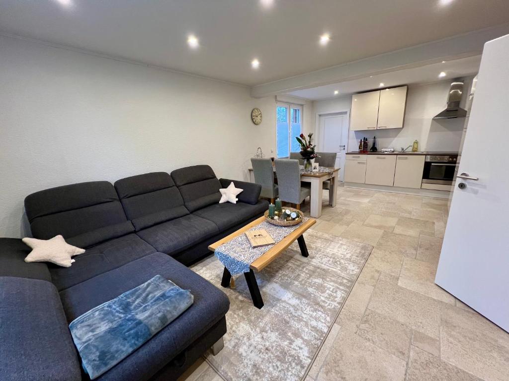 ein Wohnzimmer mit einem blauen Sofa und einem Tisch in der Unterkunft Ferienwohnung auf dem Berg in Bad Bentheim