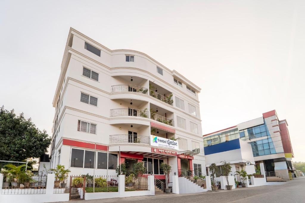 a white building with balconies on a street at Treebo Akshaya Palace Inn in Mysore