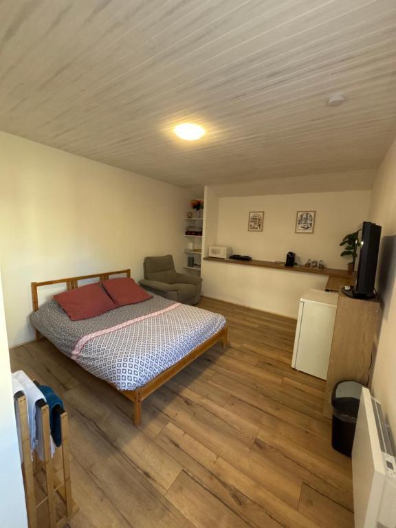 ein Schlafzimmer mit einem Bett und einem Stuhl in einem Zimmer in der Unterkunft Chez Carla in Sisteron