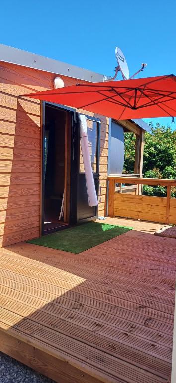 een huis met een rode paraplu op een terras bij Les chalets de ravine citrons in Entre-Deux