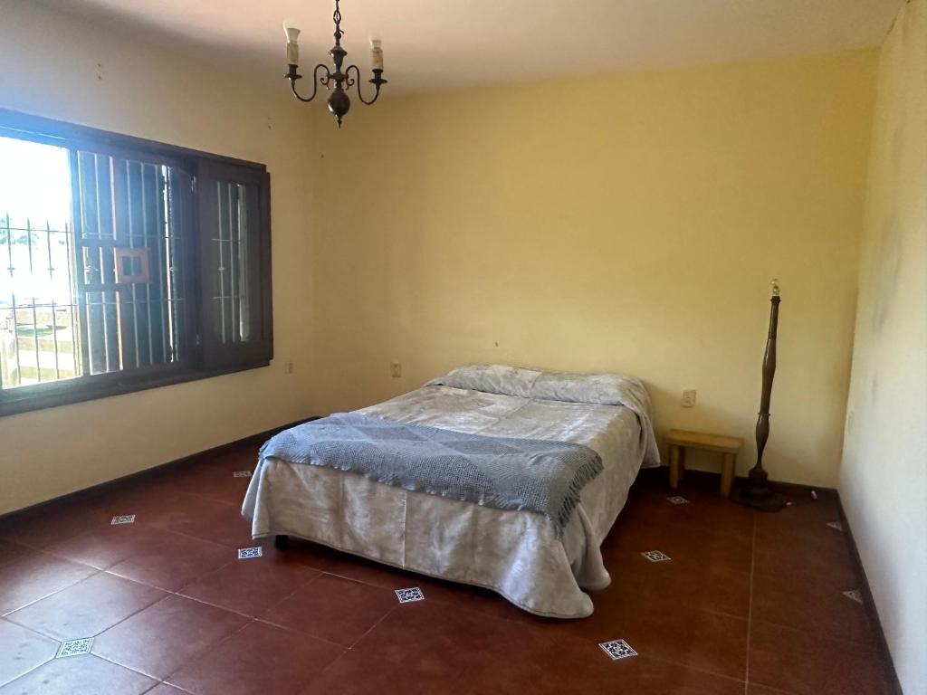 een slaapkamer met een bed en een groot raam bij Casa de Campo in Minas