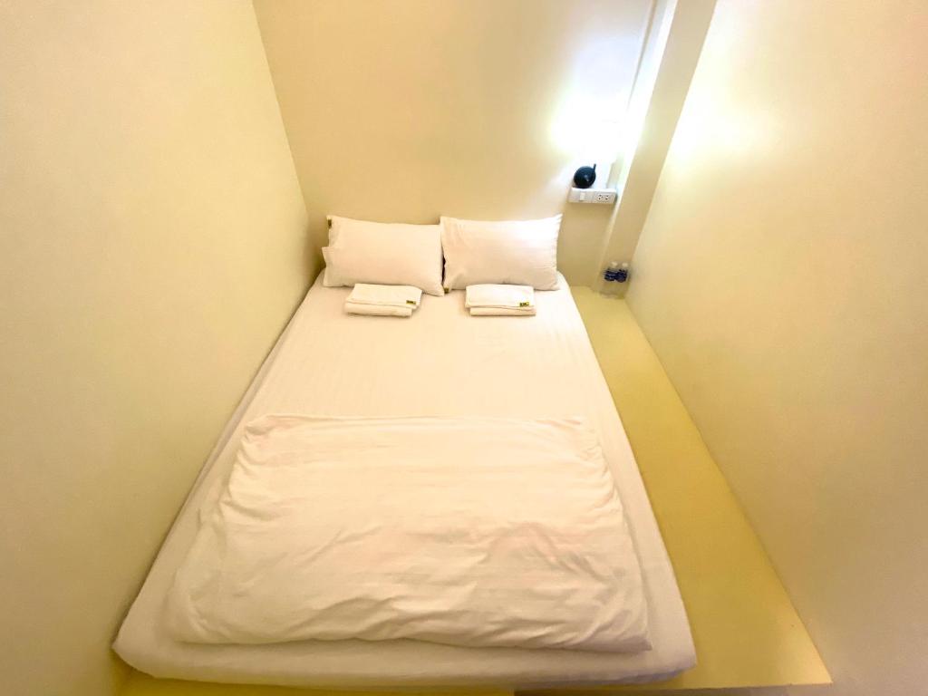 ein kleines Zimmer mit einem Bett mit zwei Handtüchern darauf in der Unterkunft Sleep At Home - Don Mueang in Ban Ko