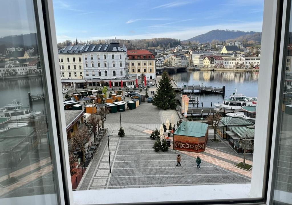 een uitzicht op een haven vanuit een raam van een stad bij Suite Marie Antoinette, Blick auf den Stadtplatz, Traunseeblick - ideal für Paare und Kulturinteressierte in Gmunden