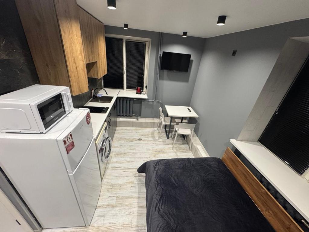 a small room with a microwave and a kitchen at TopApartment 1 in Sumy