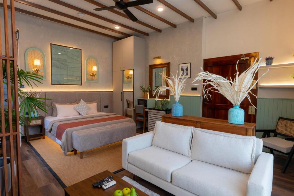 a bedroom with a bed and a couch at Mikayla Cove in Negombo