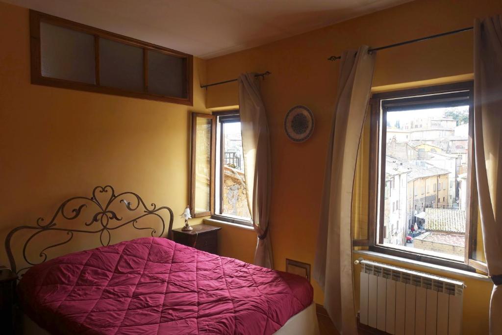 een slaapkamer met een roze bed en een raam bij Torre Verde Acquapendente in Acquapendente