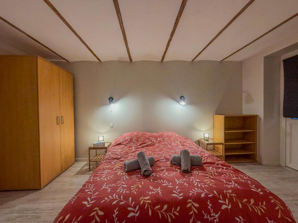 a bedroom with a red bed with two slippers on it at La Rose Urban avec Parking privé et Gare à 2 min in Nogent-le-Rotrou